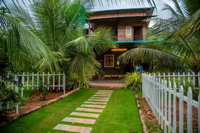 The wooden farmhouse seen from the lawn, with a stepping-stone path leading to the porch