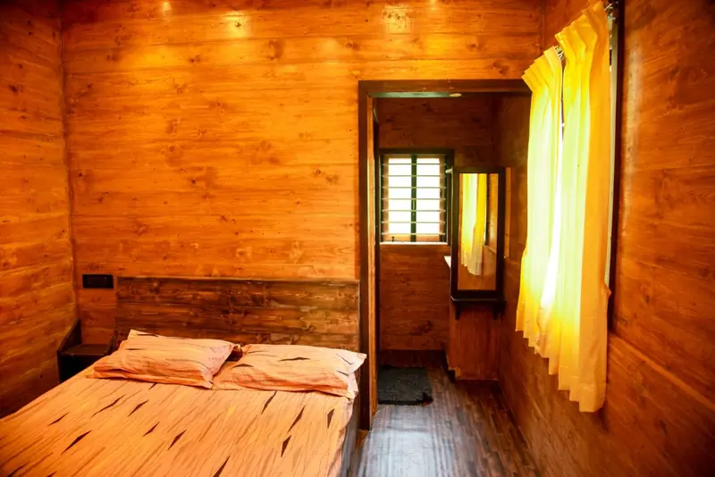 Lotus room — wood-panelled AC bedroom with double bed and ensuite bathroom