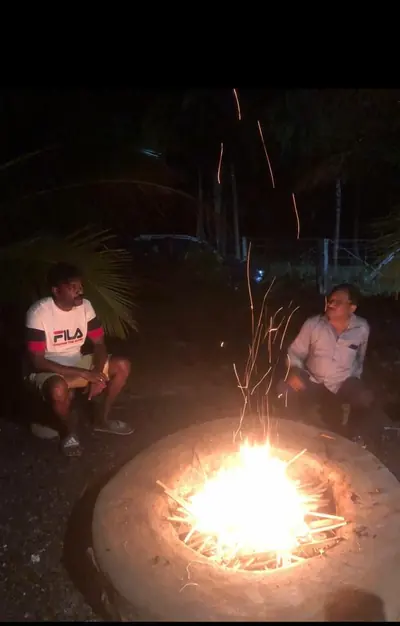 Guests around the campfire at the farm after dark