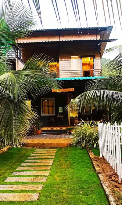The two-storey wooden farmhouse at Jungle Valley Farms, seen down the stepping-stone path