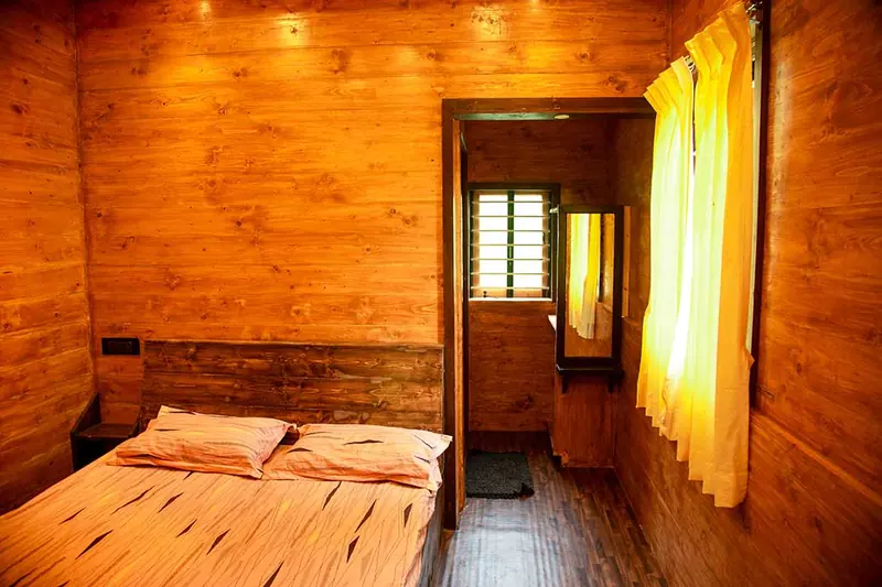 Wood-panelled bedroom with double bed and doorway to the ensuite bathroom